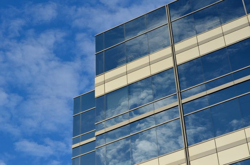 A building with many windows reflecting the sky.