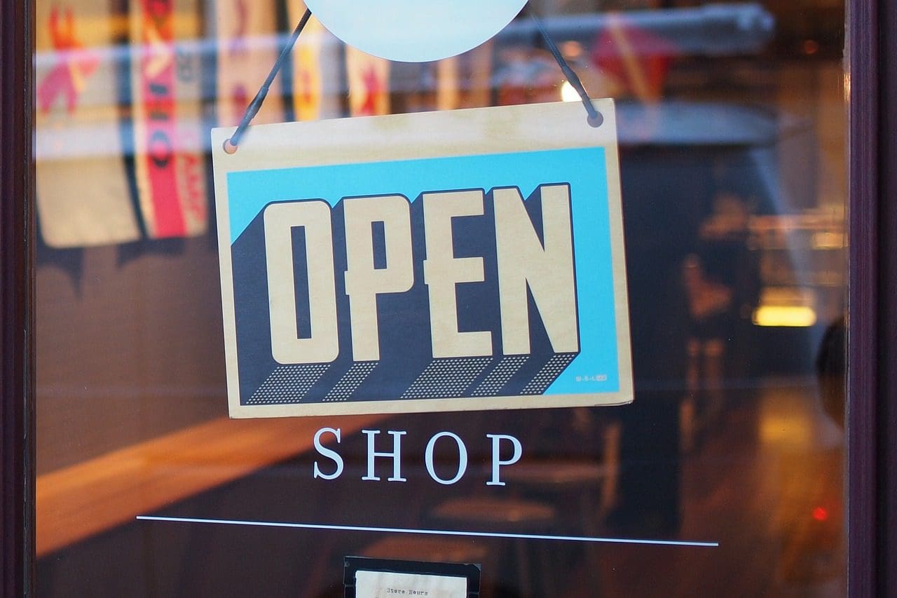 A sign that says open and the word shop.